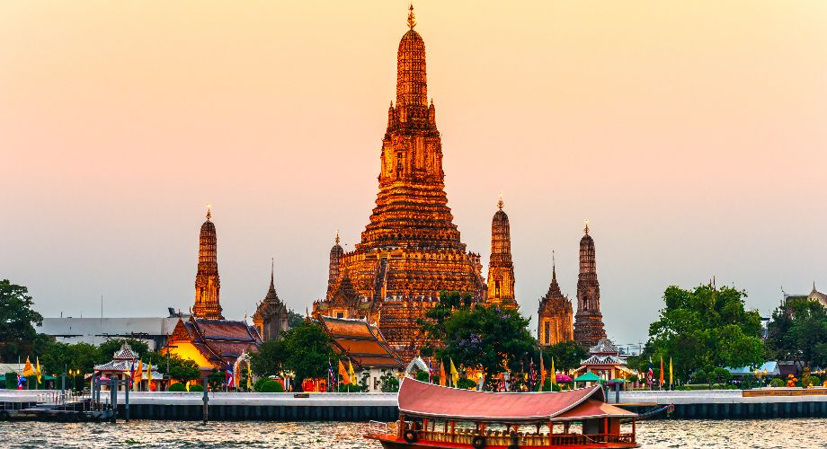 Tourist boat passing by Wat Arun Temple, Bangkok