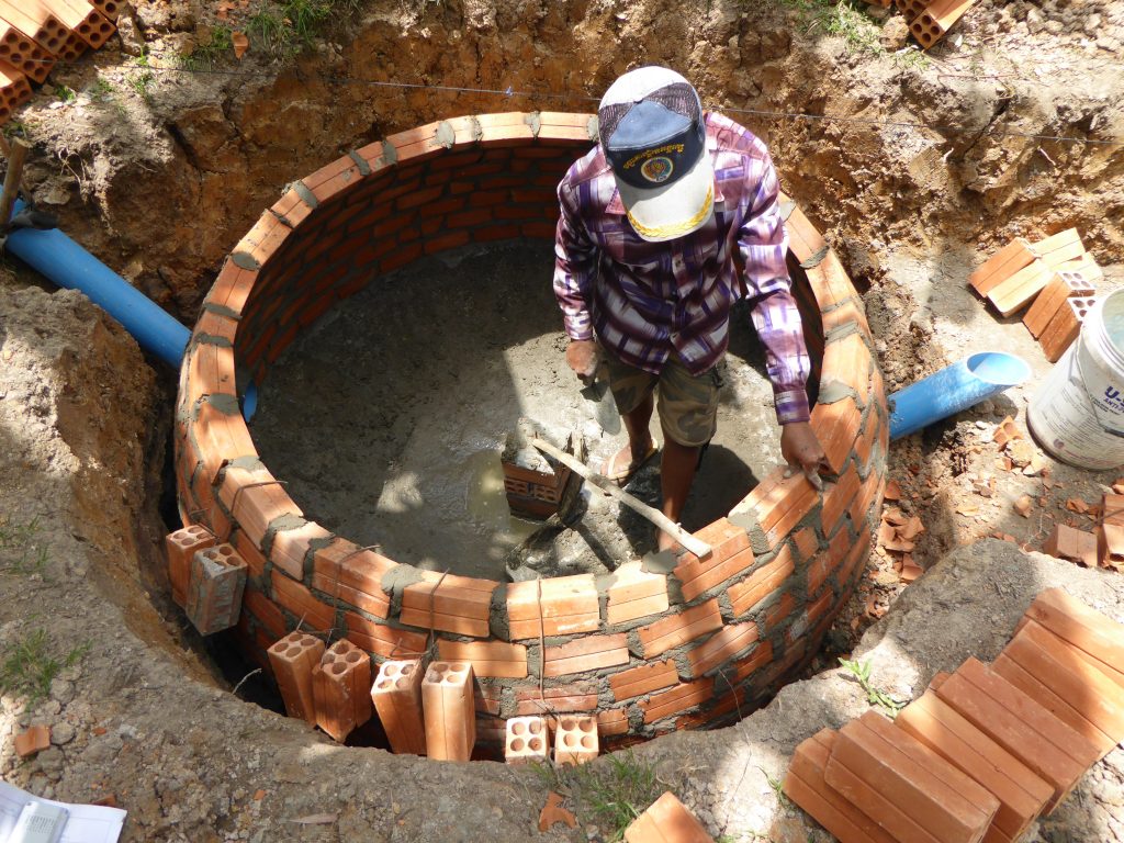 Workers constructing the firewood-saving stove for a household. 