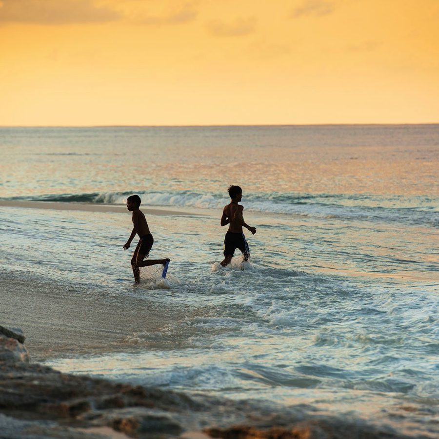 Children playing on the beach at sunset 