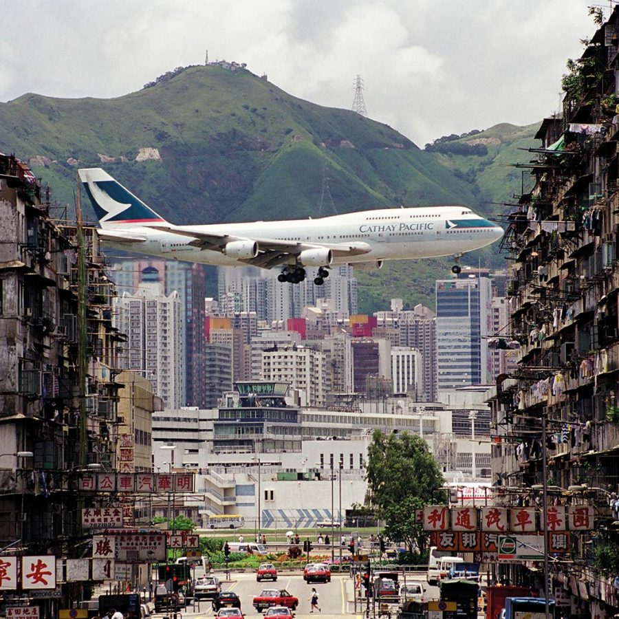 Cathay Pacific aircraft flying between buildings at Kai Tak airport