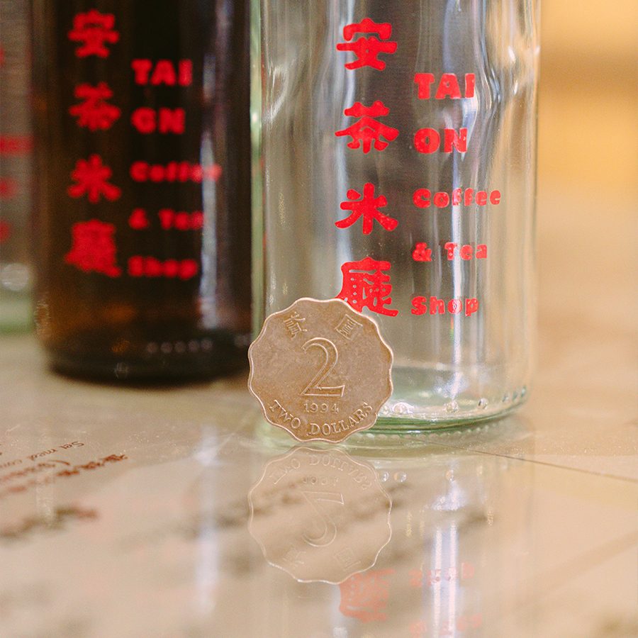 2 dollar coin against glass bottle