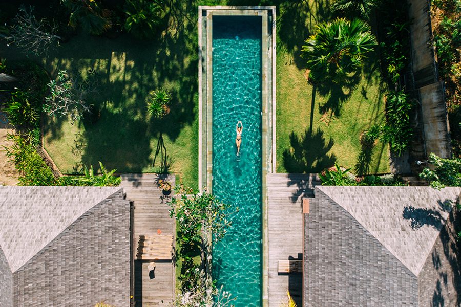 An aerial image of a woman floating in a swimming pool at a resort