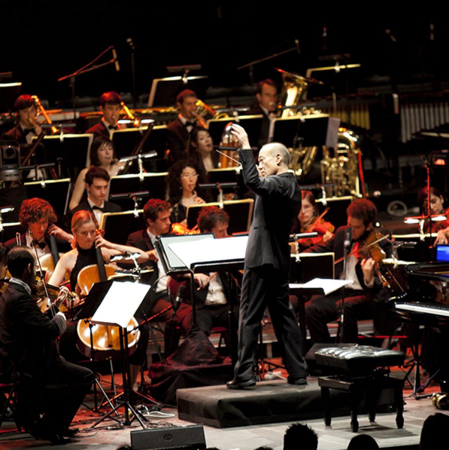 Hisaishi performs with an orchestra