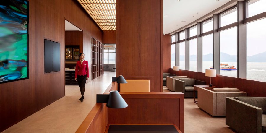 A Cathay Pacific staff in the Shekou Cruise Home Port lounge. The space is replete with wooden furnishings and looks out to the sea through large windows.