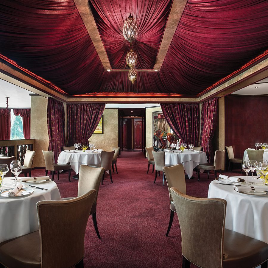 The luxurious interior of T'ang Court dining room decorated in red carpet and red drapes