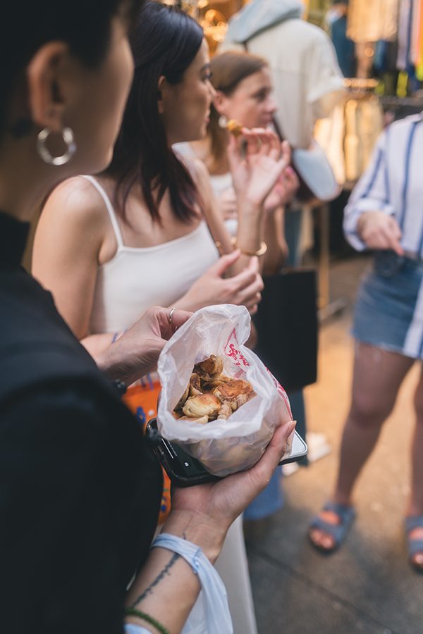 People eating traditional home made pastries during a food tour in Hong Kong