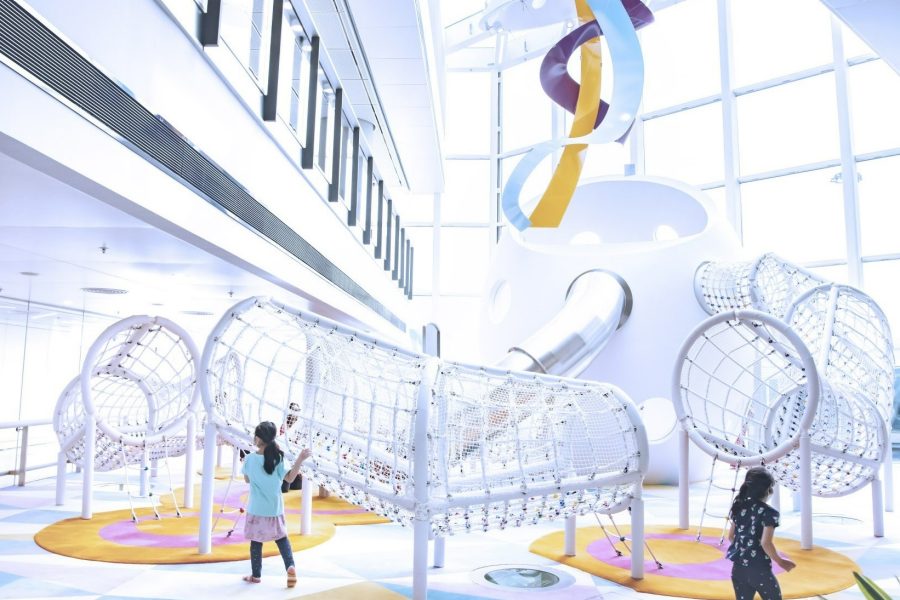 Children playing at Wonder Eggshell, a play area at Hong Kong International Airport featuring an egg-shaped structure connected to climbing nets, tunnels and slides.